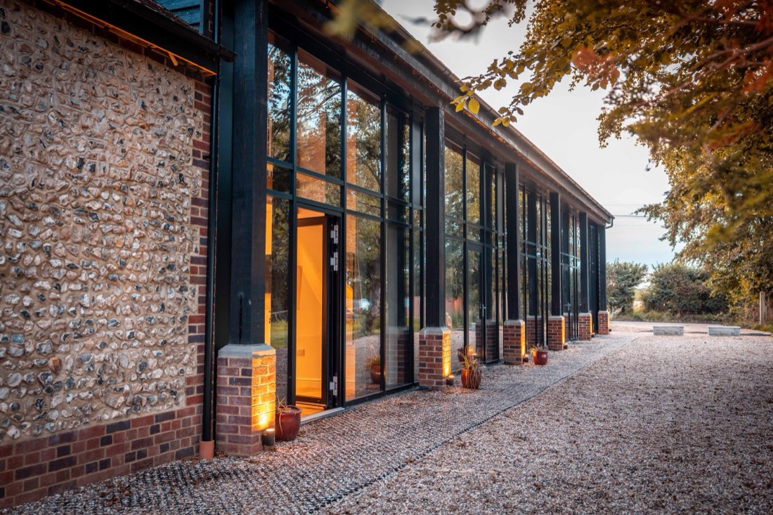 Flint wall and glazed front of the converted barns at Beaumont Mews, St Albans